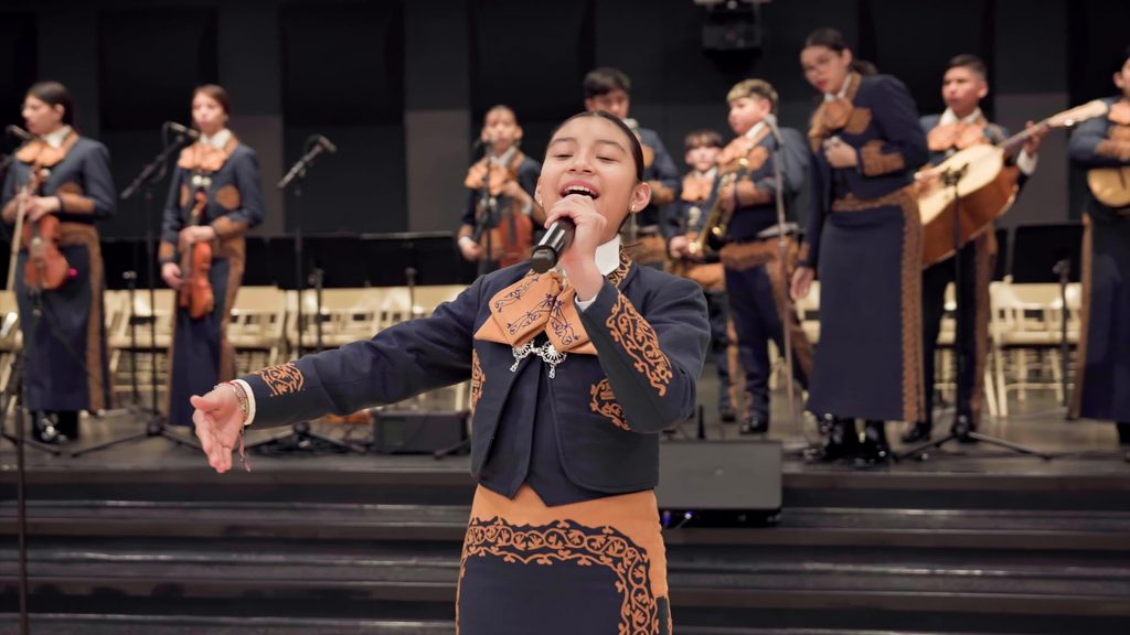 Young girl performance vocals with a mariachi band.